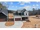 An exterior view of a two-story house with a two-car garage, a spacious driveway, and a lush green lawn at 127 Mills Garden Rd, Statesville, NC 28625