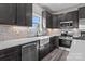 A well lit kitchen with stainless appliances, a white farmhouse sink, and tiled backsplash at 127 Mills Garden Rd, Statesville, NC 28625