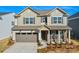 Beautiful two-story home with a gray garage door, brick accents, and a welcoming entryway at 13729 Roderick Dr # 188, Huntersville, NC 28078