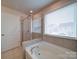 Bathroom highlighting a large soaking tub and glass-enclosed shower with tile surround at 15040 Cordelia Dr, Charlotte, NC 28278