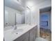 Bright bathroom featuring double vanity with gray cabinets and a large mirror at 15040 Cordelia Dr, Charlotte, NC 28278