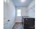 Laundry room featuring gray appliances, tile floors, and a window at 15040 Cordelia Dr, Charlotte, NC 28278