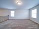 Cozy upstairs loft area with carpet flooring, perfect for a playroom or study at 15040 Cordelia Dr, Charlotte, NC 28278