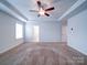 Primary bedroom showcasing a tray ceiling, ceiling fan, and two closets at 15040 Cordelia Dr, Charlotte, NC 28278