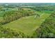 Breathtaking aerial view of a vast property with lush greenery and outbuildings at 16160 Hopewell Church Rd, Midland, NC 28107