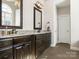 Bathroom featuring dual sinks with granite countertops, dark wood cabinets and tiled floors at 16160 Hopewell Church Rd, Midland, NC 28107