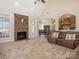 Spacious living room featuring a stone fireplace, plush carpeting, and a comfortable brown sofa at 16160 Hopewell Church Rd, Midland, NC 28107