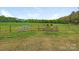 Picturesque pasture with grazing cattle behind a rustic wooden fence and gate at 16160 Hopewell Church Rd, Midland, NC 28107