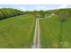 Long driveway leading to a beautiful home with expansive green fields at 16160 Hopewell Church Rd, Midland, NC 28107