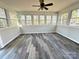 Bright sunroom with wood-look floors, lots of windows, and a ceiling fan at 16446 Doves Canyon Ln, Charlotte, NC 28278