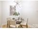 Cozy dining room with a modern chandelier and a glass-topped table and a seating for four at 1713 Archdale Dr, Charlotte, NC 28210