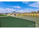 Expansive backyard with artificial turf, playground, and tree-lined border; perfect for Gathering fun and activities at 187 Tetcott St, Mooresville, NC 28115