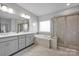 Relaxing bathroom showcasing a double vanity, framed shower door and a soaking tub at 187 Tetcott St, Mooresville, NC 28115