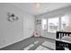 Charming bedroom featuring a crib, a chandelier, a pink armchair, and hexagon floating shelves at 187 Tetcott St, Mooresville, NC 28115