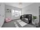 Charming bedroom featuring a crib, a chandelier, a pink armchair, and neutral walls at 187 Tetcott St, Mooresville, NC 28115
