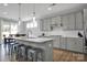Well-lit kitchen showcasing a central island with seating, stainless appliances, and a view of the breakfast nook at 187 Tetcott St, Mooresville, NC 28115
