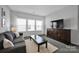 Cozy living room featuring a comfortable gray sofa, a dark wood tv console, and plenty of natural light at 187 Tetcott St, Mooresville, NC 28115