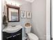 Charming powder room with a modern vanity, decor, and a decorative mirror providing a warm and inviting space at 1916 Pegram St, Charlotte, NC 28205