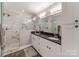 Elegant main bathroom with dual sinks, granite counters, and a large shower with luxurious marble tiling at 1916 Pegram St, Charlotte, NC 28205