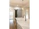 Bright kitchen island featuring marble countertops, a sink, and stainless steel appliances with a sliding barn door pantry at 19908 Wooden Tee Dr, Davidson, NC 28036