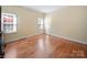Empty bedroom featuring hardwood floors and two windows at 2217 Blue Bell Ln, Charlotte, NC 28270