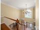 View from the second story to the foyer featuring a chandelier, large window, and hardwood floors at 2217 Blue Bell Ln, Charlotte, NC 28270