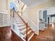 Stunning foyer boasts high ceilings, wood floors, and a beautiful staircase with natural light pouring through a large window at 2217 Blue Bell Ln, Charlotte, NC 28270
