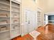 Bright foyer with hardwood floors, built-in bookshelves, and a white front door at 2217 Blue Bell Ln, Charlotte, NC 28270