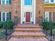Inviting brick steps lead to a charming red front door with decorative details and sidelight windows at 2217 Blue Bell Ln, Charlotte, NC 28270