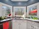 Bright kitchen featuring granite counters, white cabinets, and a stainless steel sink with a great view of the backyard at 2217 Blue Bell Ln, Charlotte, NC 28270