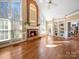 Bright living room featuring a brick fireplace, hardwood floors, and built-in bookshelves at 2217 Blue Bell Ln, Charlotte, NC 28270