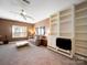 Cozy living room with built-in shelving, ceiling fan, and comfortable seating at 2217 Blue Bell Ln, Charlotte, NC 28270