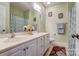 Bathroom with double sinks, white cabinets, a tile floor, and a shower/tub with a curtain at 2689 Wingrave Nw St, Concord, NC 28027