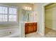 Bathroom vanity with dark wood cabinets, a tile floor, and a view of the bathtub at 2689 Wingrave Nw St, Concord, NC 28027