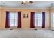 A bright bedroom with neutral carpet, a ceiling fan, and large windows, offering plenty of natural light at 2689 Wingrave Nw St, Concord, NC 28027