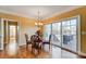 A cozy dining area with hardwood floors, a chandelier, and a sliding glass door leading to the outdoor deck at 2689 Wingrave Nw St, Concord, NC 28027
