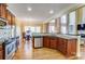 A well-lit kitchen with stainless steel appliances, wooden cabinetry, and granite countertops overlooking the dining area and living room at 2689 Wingrave Nw St, Concord, NC 28027