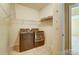 Functional laundry room with modern washer and dryer set, shelves, and neutral color palette at 2689 Wingrave Nw St, Concord, NC 28027