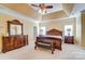 Spacious main bedroom featuring a tray ceiling, a ceiling fan, and a sitting bench at 2689 Wingrave Nw St, Concord, NC 28027