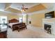 A luxurious main bedroom featuring a tray ceiling, fireplace, and an ensuite bathroom, all with elegant design elements at 2689 Wingrave Nw St, Concord, NC 28027