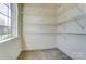 Bright walk-in closet with multiple shelves and a window for natural lighting and ventilation at 2689 Wingrave Nw St, Concord, NC 28027