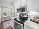 Modern kitchen features stainless steel appliances, granite countertops, and view to windowed room at 2727 Tiergarten Ln, Charlotte, NC 28210