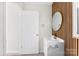 Modern bathroom featuring a sleek vanity, round mirror, and unique vertical wood paneling for a stylish touch at 2729 Springbrook Cir, Gastonia, NC 28052