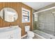 Updated bathroom features custom wood wall, round mirror, and glass-enclosed shower at 2729 Springbrook Cir, Gastonia, NC 28052