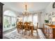 Bright dining room featuring a large window, elegant chandelier, and stylish decor and furniture at 2745 Bonnybrook Cir, Rock Hill, SC 29732