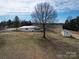 An aerial view showing the one story home, a storage shed and the surrounding rural land at 2890 South River Church Rd, Woodleaf, NC 27054