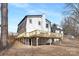 A shot of the back of the house with a large wooden deck, supports underneath, and a sloped backyard at 301 Dollar Cir, Charlotte, NC 28270
