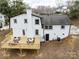 Renovated home featuring a new wooden deck, white painted brick and siding, and a dark grey shingled roof at 301 Dollar Cir, Charlotte, NC 28270