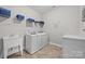 Well-organized laundry room with washer, dryer, sink, and shelving for storage at 3173 Delaware Dr, Denver, NC 28037