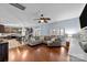 Open-concept living room featuring hardwood floors, a comfortable sectional sofa, and an adjacent kitchen area at 3173 Delaware Dr, Denver, NC 28037